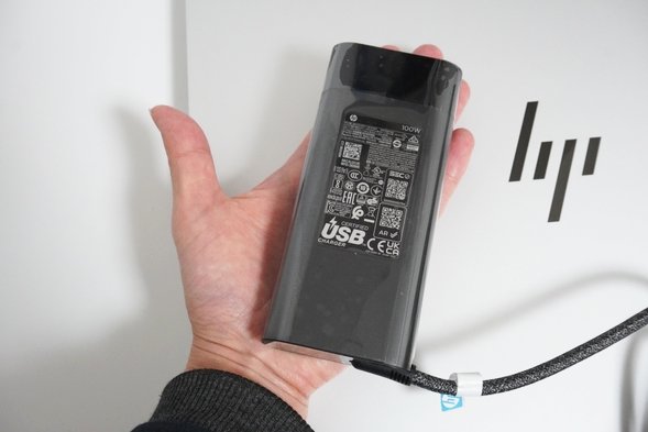 HP OmniBook 7 16-ayのACアダプターを手のひらに乗せたところ